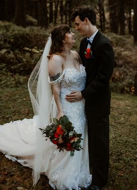 Happy couple standing in front of flower arch - in Ridgefield, WA