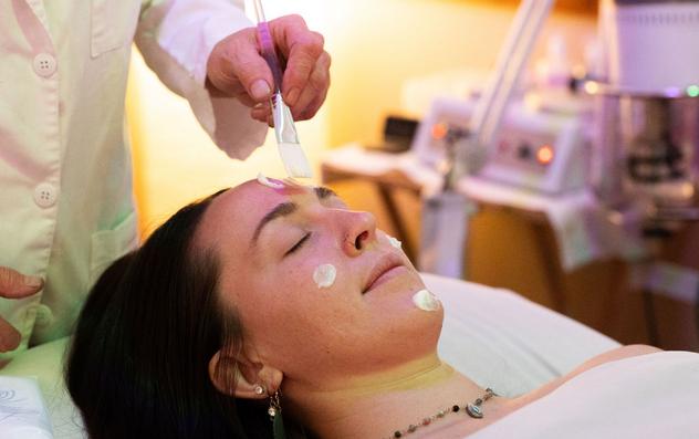 Client getting a facial by an esthetician at Balance Holistic Health Spa