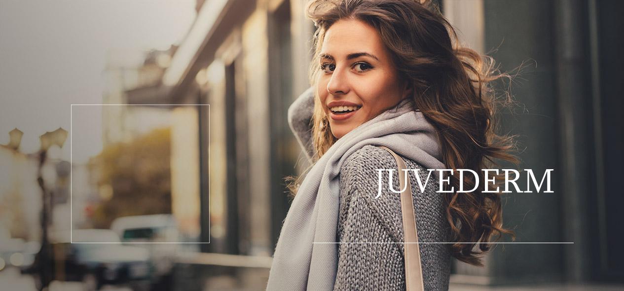 Woman walking in a city, smiling over her shoulder. Find information about the dermal filler Juvederm down below!