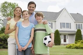 Smiling family outside home