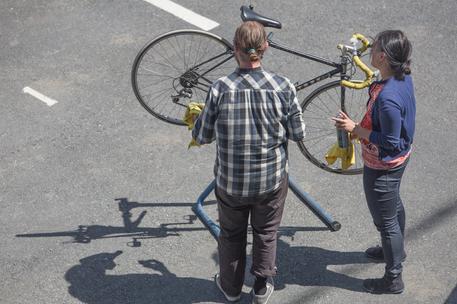 male and female working on bicycle outside in sunshine