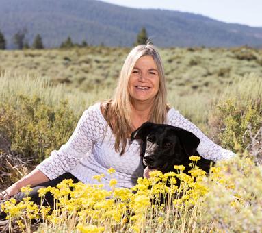 Valerie the owner who is a massage therapist and esthetician with her Dog Sadie in a field