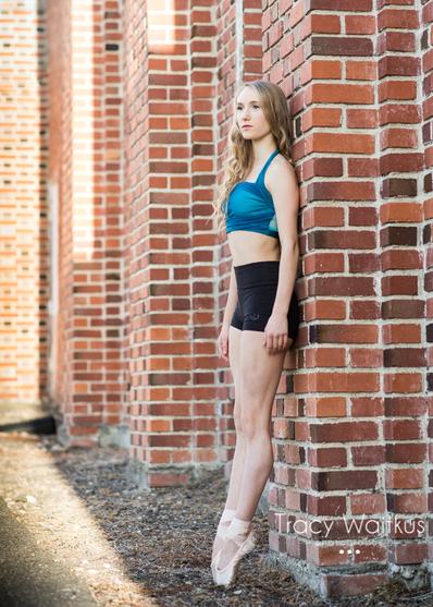 ballerina posing by a brick wall in Pismo Beach