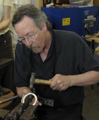 artist Kevin O'Dwyer at the metalsmithing workbench