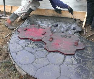 Random stone stamped concrete patio and sidewalk walkway in silver gray integral liquid color with charcoal antique release.