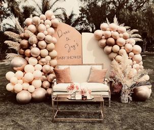 Boho baby shower backdrop with balloons half arches panmpas grass and dried palms