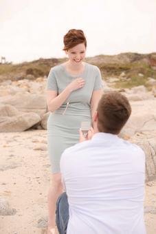 engagement photography man on knee proposing to woman on beach in Monterey Bay by engagement and couples photographer