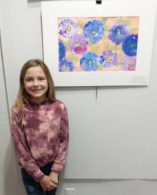 Claire Elise Parker posing with her Mixed Media piece, Price of Consumption