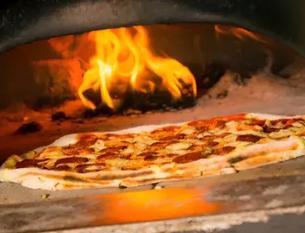 Gourmet pizza baking inside a wood burning pizza oven