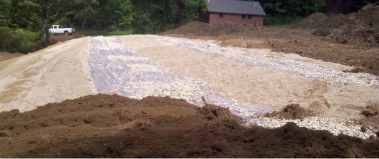 Two rows of concrete trench boxes plus pipe and stone in select septic sand.