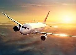 Large jumbo jet flying in the sky above clouds with bright golden sun shown at the back.