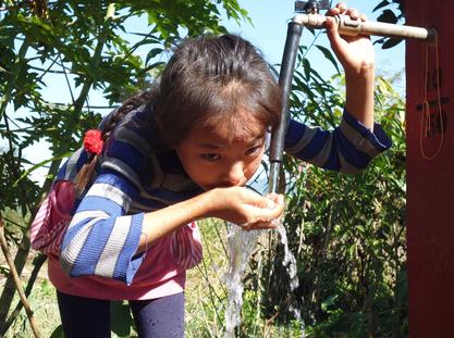 Young Gurkha child drinking from a GWT water tap in Nepal