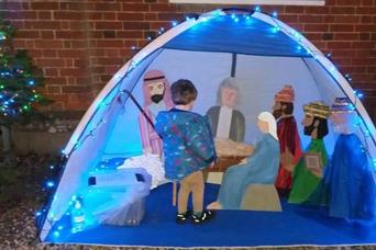 Image of child looking at tent with nativity scene inside