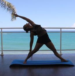 Yoga teacher practicing stretching poses for Flexibility in a balcony in front of the. Ocean Salutation to the sun for the improvement of overall body flexibility.