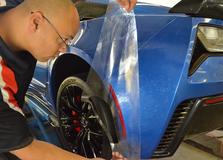 Certified technician installing an invisible bra on a car in Indianapolis, IN