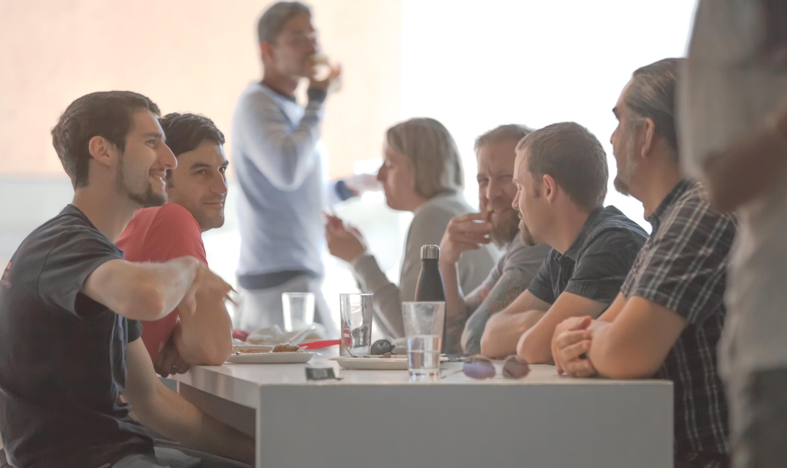 group of males having interaction with blurry office barbecue background