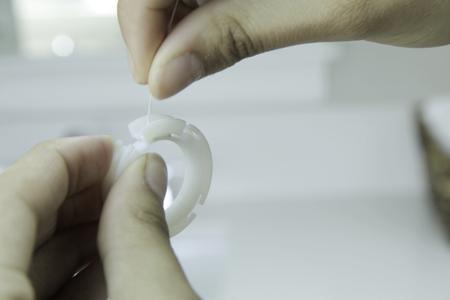 Model demonstrating how to refill Zip Rings with any brand or type of dental floss.