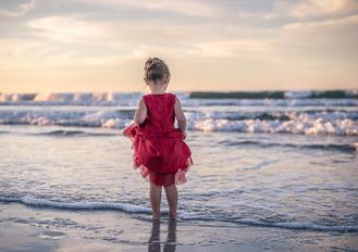 children family photography girl red dress in ocean Monterey Bay