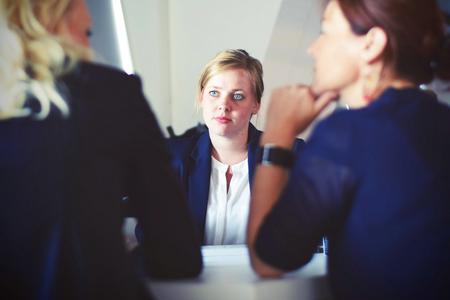 Woman listening attentively as two women have a discussion