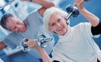 Mature Couple exercising with weights in a private fitness retreat for toning, muscle conditioning and strength..