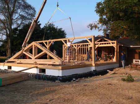 Crane lifting sections of a timber frame building into place