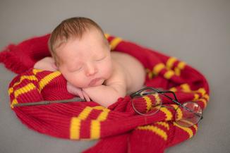newborn baby harry potter sleeping on scarf with wand and glasses nearby newborn photography