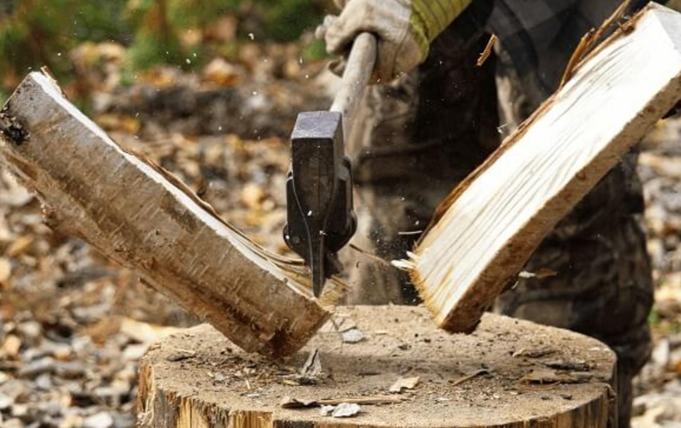 An axe coming down chopping hardwood firewood