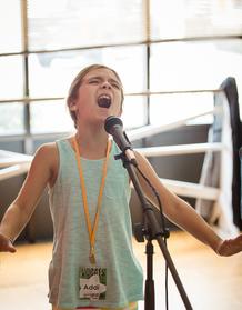 Young girl singing into a microphone