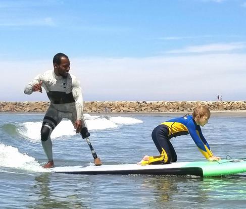 Blind Surfer Josh "the Jedi Loya teaching a surf lesson on the beach. Link to Waves4all Surf Page.
