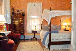 Special Amenity Rooms & Suites - Image of the Canopy Room in the Wedgwood Inn. Stenciled walls, lace canopy on bed, Victorian chairs, antique furniture.