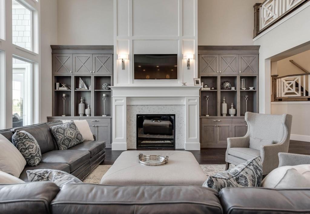 Custom wood built-in cabinets, shelving, and wainscot wood wall around fireplace.