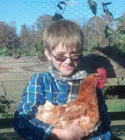 Colby's Army photo of a boy holding a red chicken