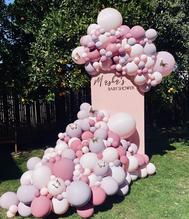 Baby shower balloon installation on pink wall with butterflies