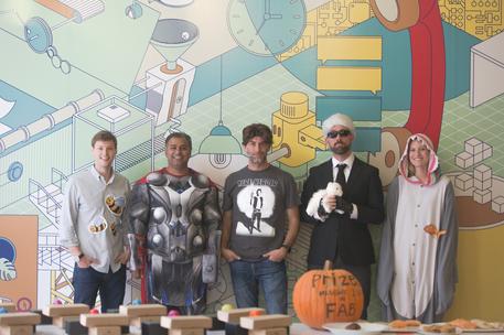 group of tech employees costume contest in front of mural bay area