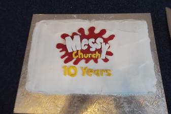 Cake with writing 'Messy Church 10 years'