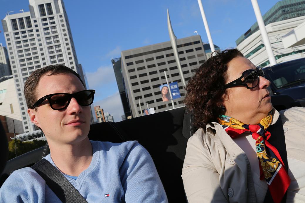 two people in convertible car blue sky
