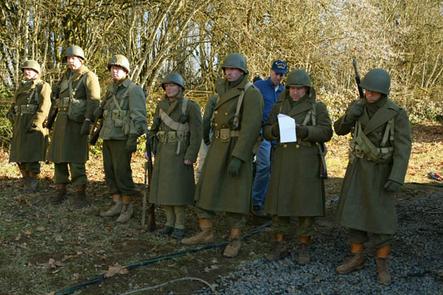 Military consultant Jay Lance inspects actors portraying WW2 GI