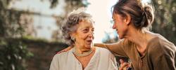 Elderly woman being comforted by a caregiver