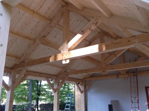 Inside of a timber frame building with a freshly installed roof.