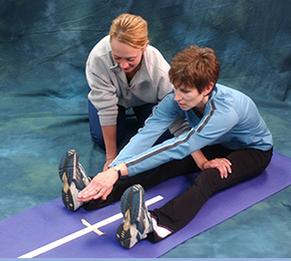 Trainer testing client's hip and hamstring flexibility