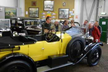 Group looking at antique yellow car