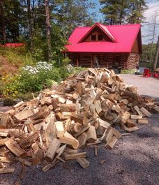 Firewood dumped in front of cottage for a delivery