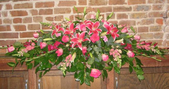 Spray done in pinks and fuchsias, with stargazers, snapdragons, gladioli, filler flower and greens