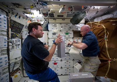 NASA astronauts Greg Chamitoff (left), mission specialist, and Mark Kelly, mission commander, are unpacking canisters of the Group Activation Pack.