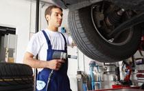 mechanic screwing hubcaps on tire