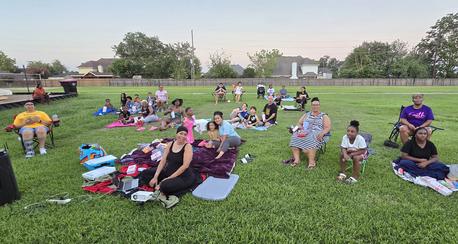 Photo of Laure Oaks residents sitting on the lawn of green grass in the Laurel Oaks Park