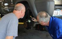 mechanic explaining needed automotive service to customer