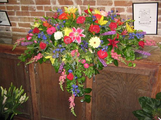 Spray in jewel tones with lilies, liatris, gerbera daisies, delphinium, snapdragons, roses, and Matsumoto with filler