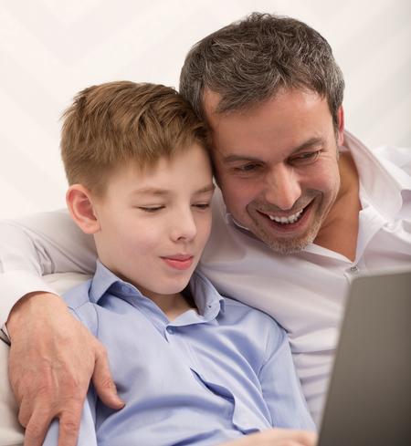 Father and son looking at photos on laptop