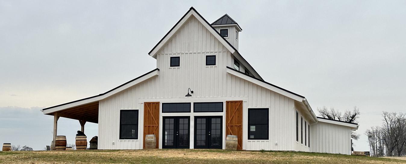 40x60 wedding barn with white board and batton siding and black windows and doors
